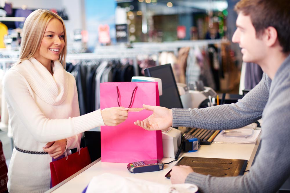 cliente paye le vendeur dans un magasin de vêtements