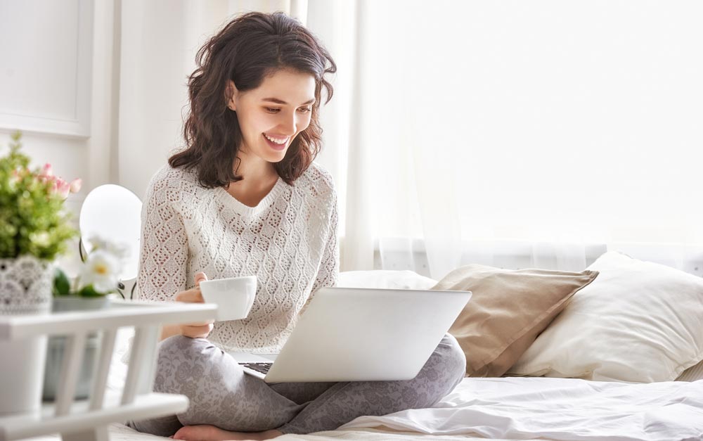 Jeune femme découvrant avec joie une annonce sur son ordinateur